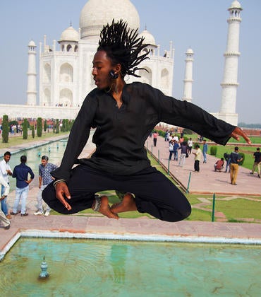 Male UCR student jumping in front of the Taj Mahal